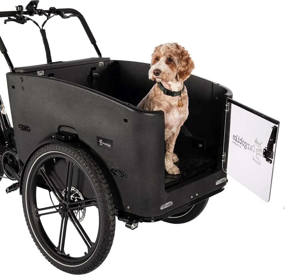 Hund sitter i Cargobike Delight Nova Dog med den genomskinliga luckan öppen