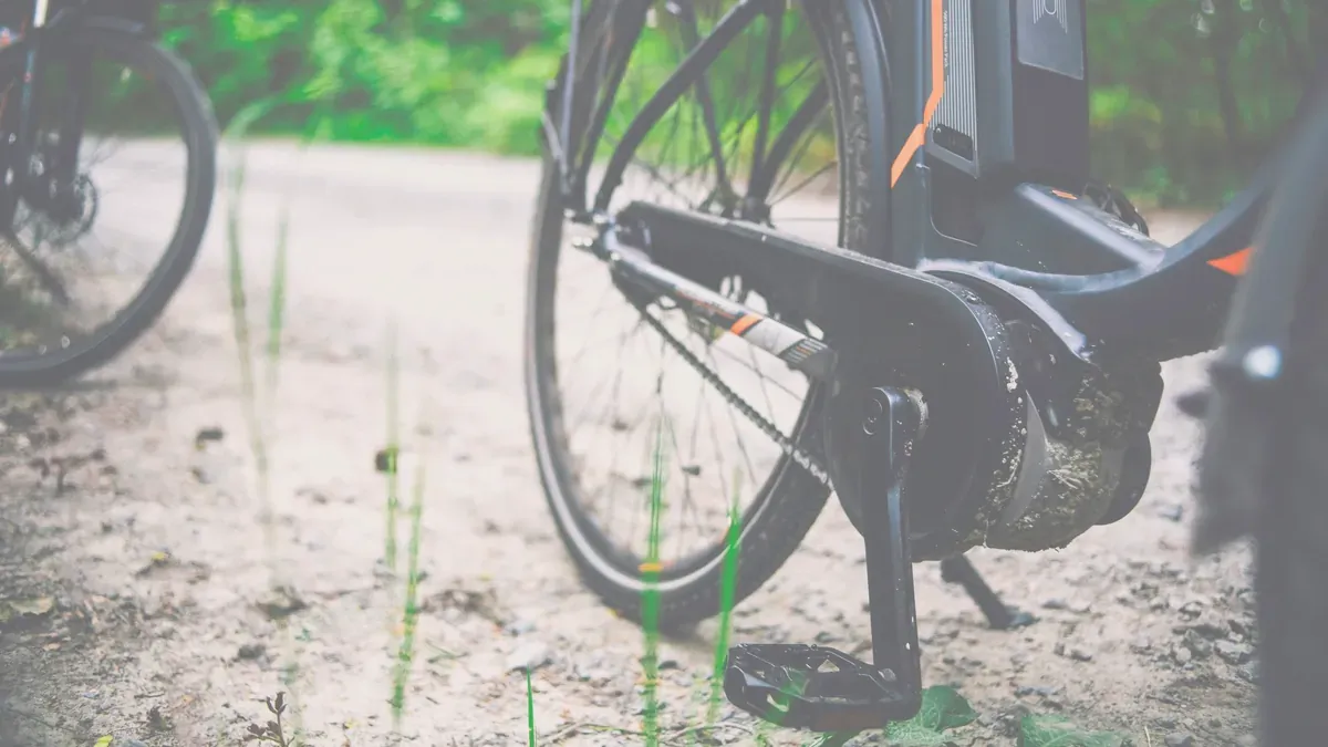 Närbild på en elcykels mittmotor vid vevpartiet med batteriet monterat i ramen ovanför